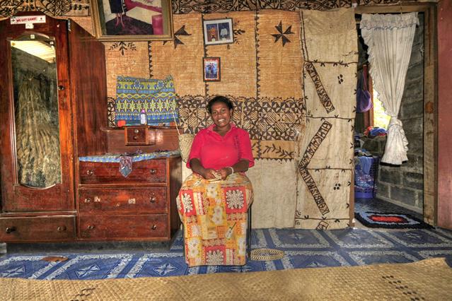 Tania erwartet ihr zweites Kind und wir machen ein Foto von ihr in ihrem Haus vor dem wunderschönen Wandbehang aus bearbeiteter Rinde. Diese Wandbehänge sieht man in fast allen Häusern der Fijianer.